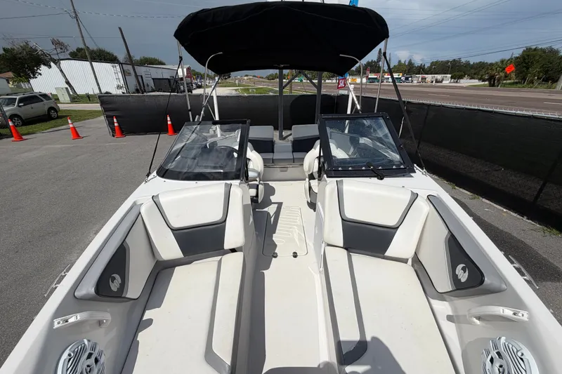 Slide: The Image of 2018 Scarab 195 G boat interior with seating and windshield, parked outdoors. - 43
