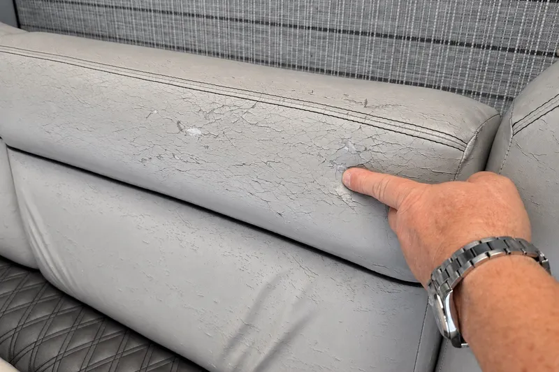 Slide: The Image of Cracked upholstery on 2020 Barletta L-CLASS L25QCSSA boat seat, finger pointing at damage. - 46
