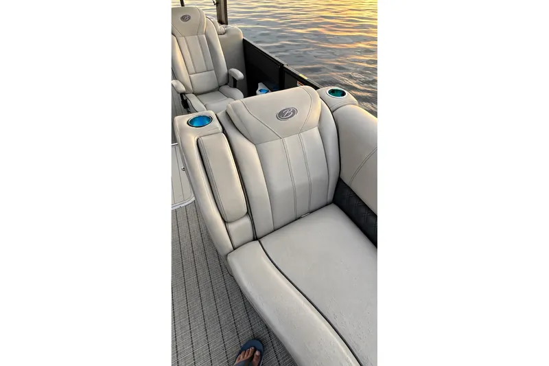 Slide: The Image of 2020 Barletta L-Class L25QCSSA boat seats with cup holders, on water at sunset. - 29