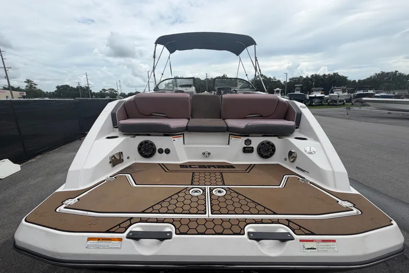 Slide: The Image of 2018 Scarab 255 ID boat with cushioned seating and deck, parked outdoors. - 11