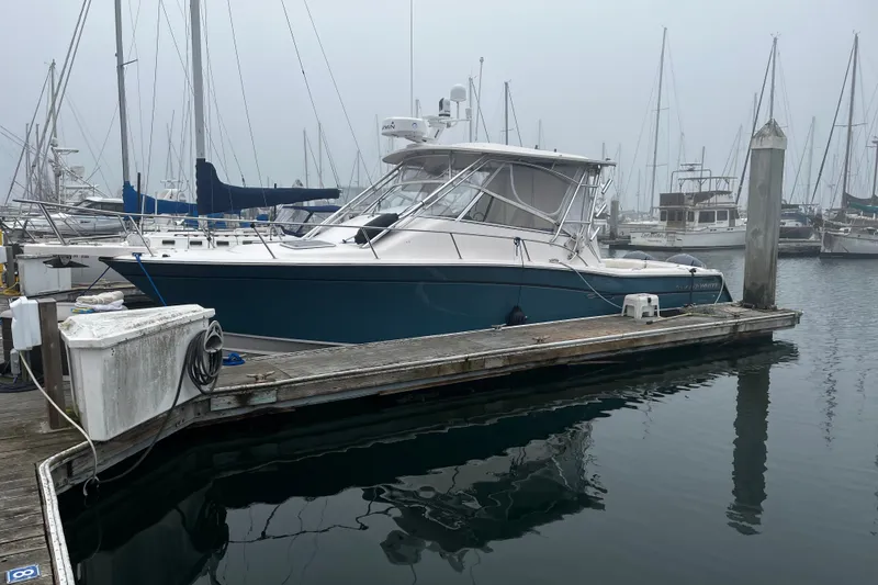 Slide: The Image of 2003 Grady-White Express 330 boat docked at a marina on a foggy day. - 3