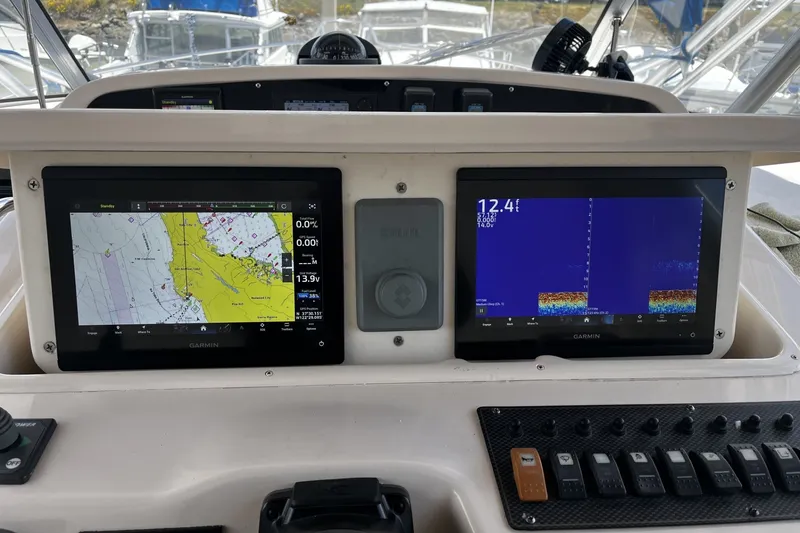 Slide: The Image of Dashboard of a 2003 Grady-White Express 330 with Garmin navigation displays. - 8