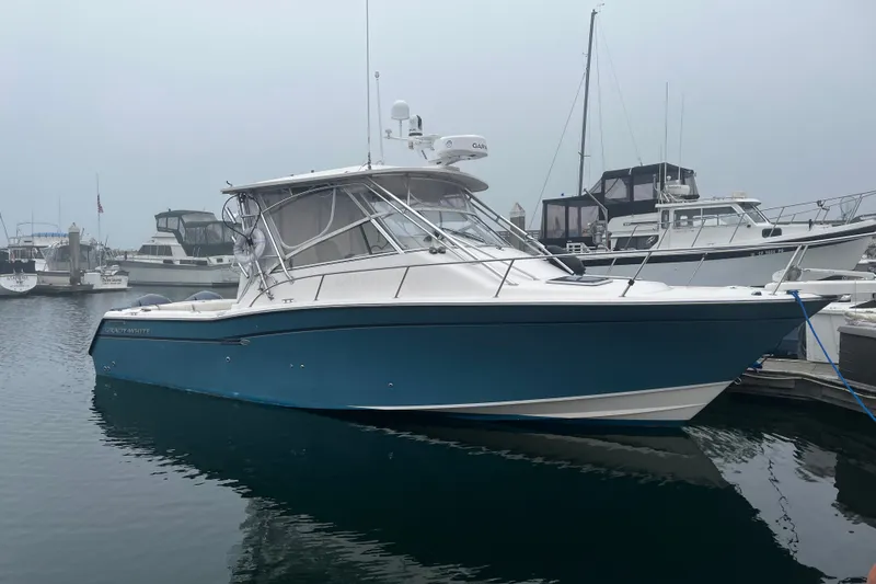 Slide: The Image of 2003 Grady-White Express 330 boat docked in a marina, featuring a sleek blue hull. - 1