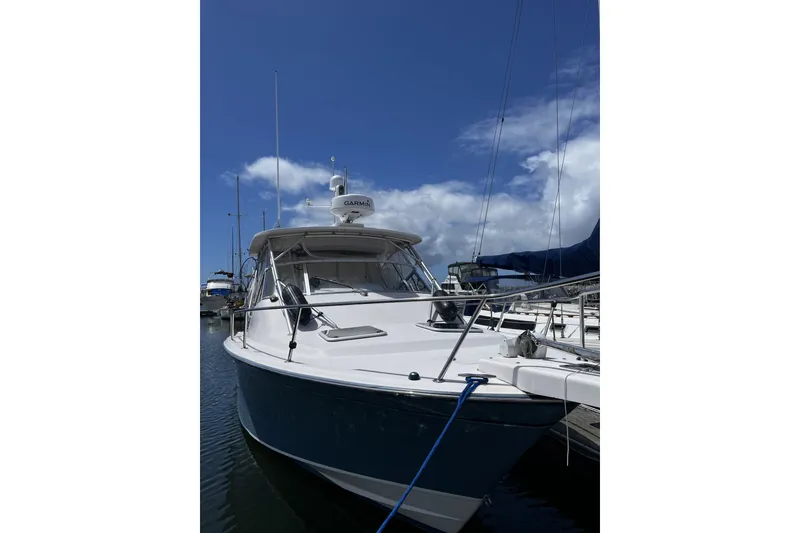 Slide: The Image of 2003 Grady-White Express 330 boat docked under a clear blue sky. - 4