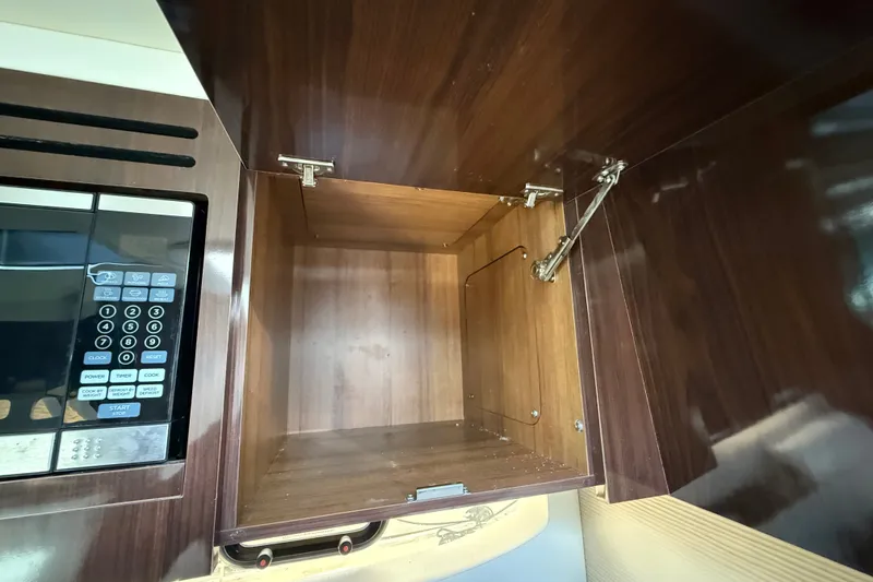 Slide: The Image of Open wooden cabinet and microwave in 2018 Sea Ray Sundancer 350 Coupe yacht kitchen. - 36
