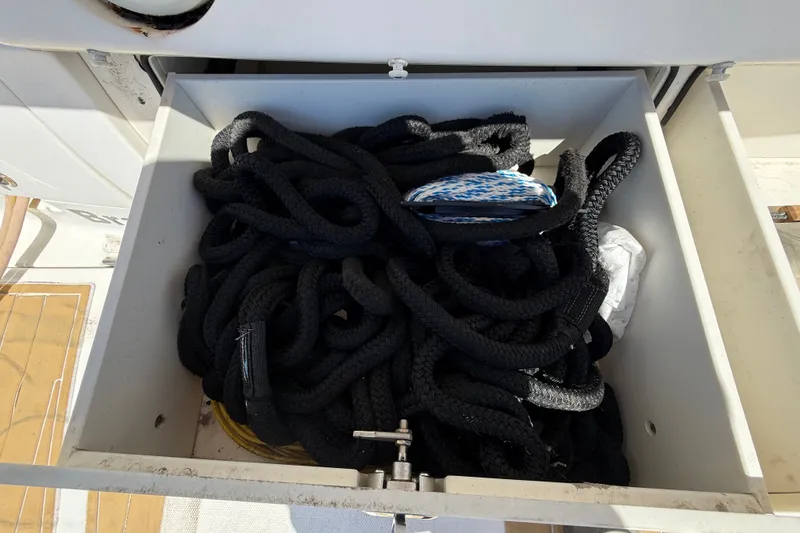 Slide: The Image of Storage compartment on 2018 Sea Ray Sundancer 350 Coupe with black ropes and accessories. - 125