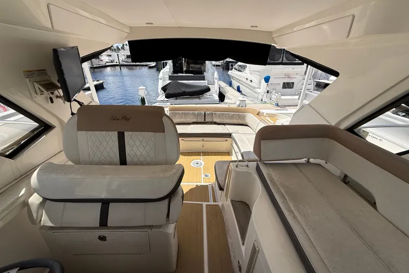 Slide: The Image of Interior view of 2018 Sea Ray Sundancer 350 Coupe, featuring luxurious seating and marina backdrop. - 74