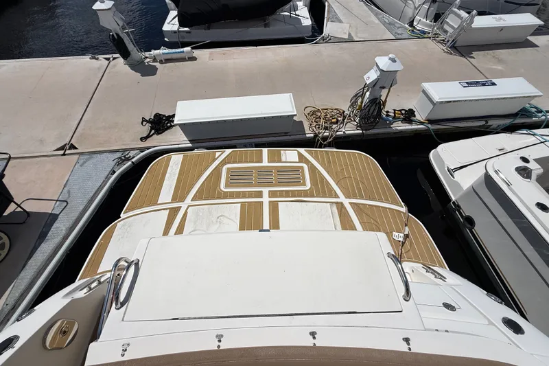 Slide: The Image of 2018 Sea Ray Sundancer 350 Coupe docked, showcasing spacious deck and marina surroundings. - 95
