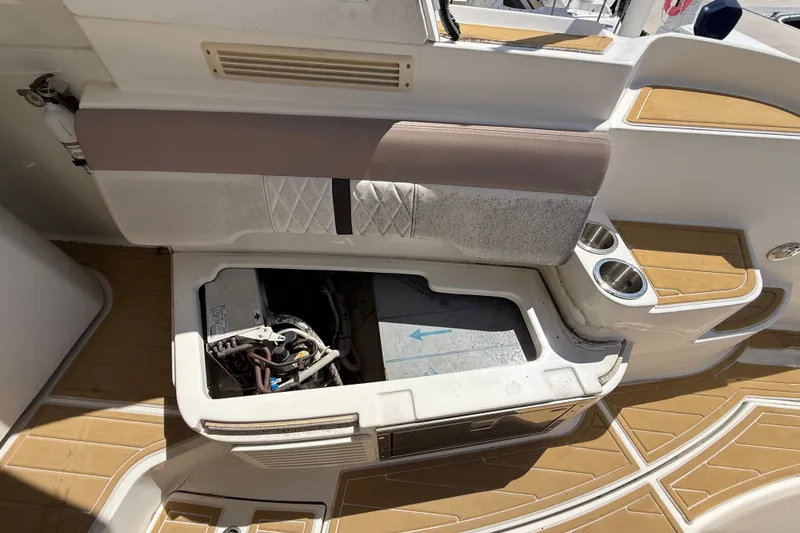 Slide: The Image of 2018 Sea Ray Sundancer 350 Coupe interior with open storage compartment and cup holders. - 88