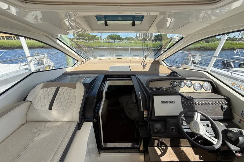 Slide: The Image of 2018 Sea Ray Sundancer 350 Coupe cockpit with steering wheel, Simrad display, and seating. - 23