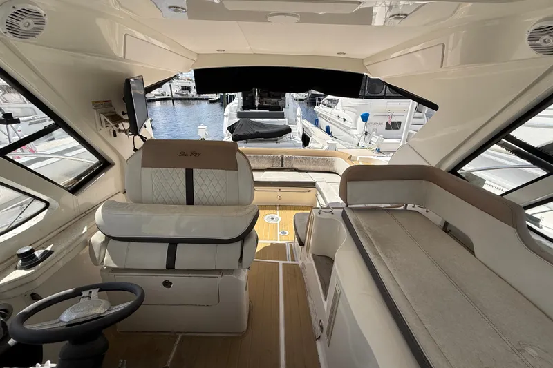 Slide: The Image of Interior of 2018 Sea Ray Sundancer 350 Coupe, featuring luxurious seating and helm, docked at marina. - 73