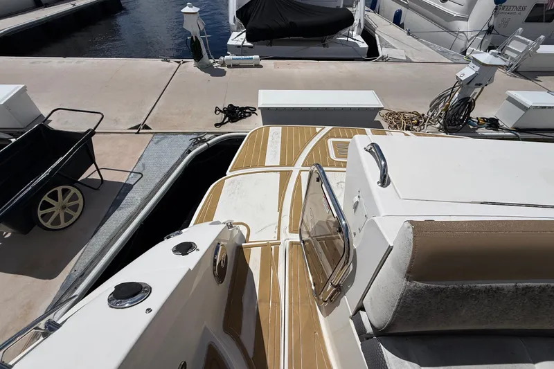 Slide: The Image of 2018 Sea Ray Sundancer 350 Coupe docked, showcasing deck and marina surroundings. - 98