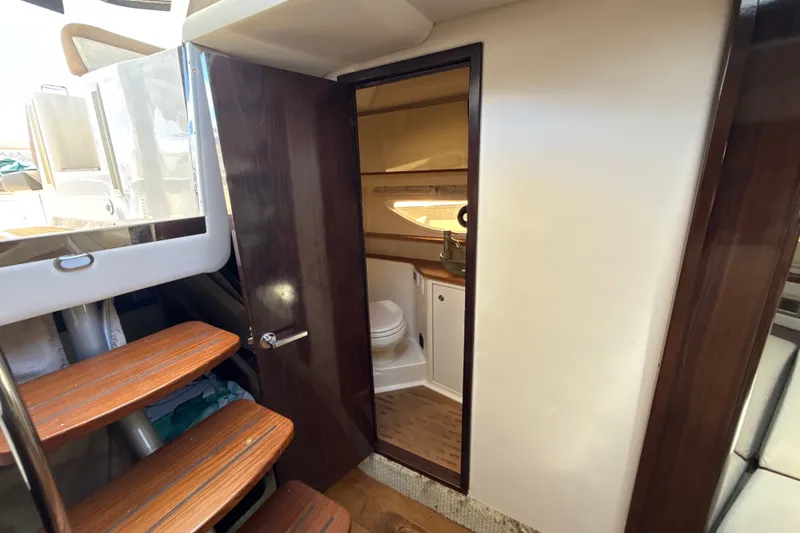 Slide: The Image of Interior view of 2018 Sea Ray Sundancer 350 Coupe, featuring wooden stairs and a compact bathroom. - 62