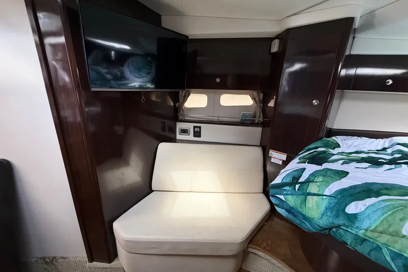 Slide: The Image of 2018 Sea Ray Sundancer 350 Coupe interior with TV, seating, and bed. - 48