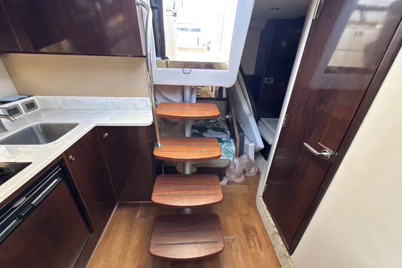 Slide: The Image of Interior of 2018 Sea Ray Sundancer 350 Coupe with wooden stairs and modern kitchen. - 61