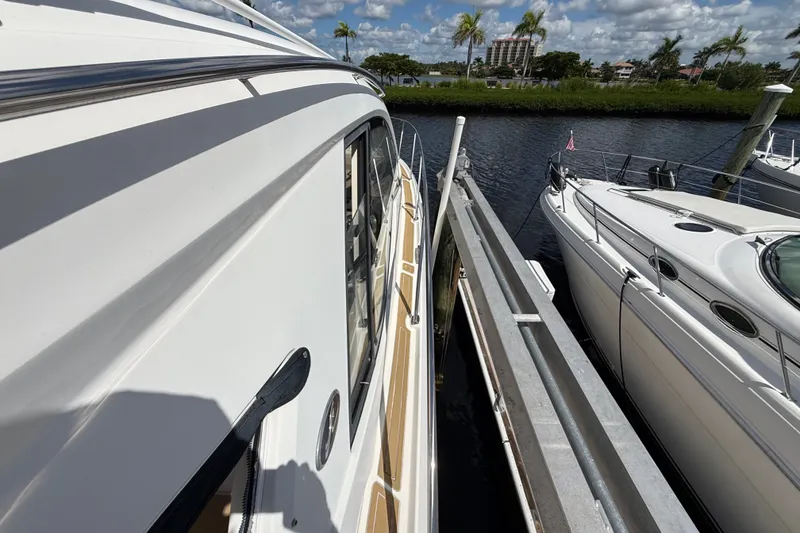 Slide: The Image of 2018 Sea Ray Sundancer 350 Coupe docked beside another boat, under a sunny sky. - 101