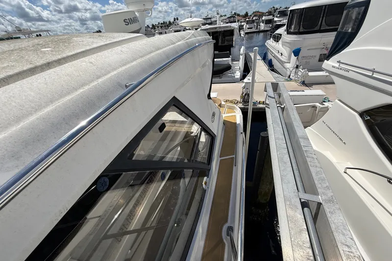 Slide: The Image of 2018 Sea Ray Sundancer 350 Coupe docked at marina under cloudy sky. - 119