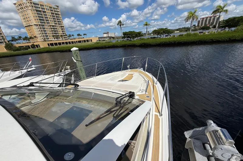 Slide: The Image of 2018 Sea Ray Sundancer 350 Coupe docked near waterfront buildings and palm trees. - 104