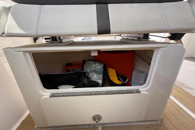 Slide: The Image of Storage compartment on a 2018 Sea Ray Sundancer 350 Coupe boat, containing safety equipment. - 76