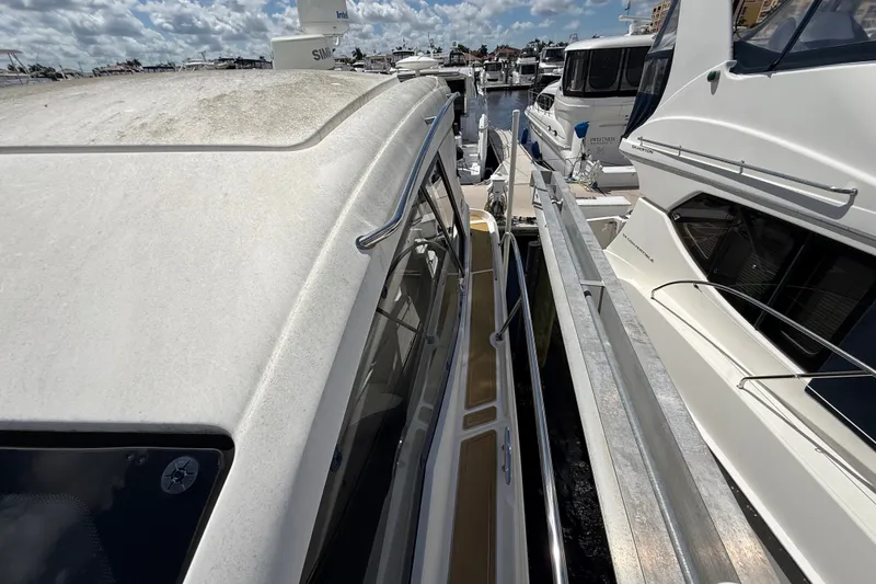 Slide: The Image of 2018 Sea Ray Sundancer 350 Coupe docked among other boats under a partly cloudy sky. - 118