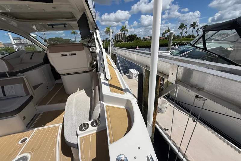 Slide: The Image of 2018 Sea Ray Sundancer 350 Coupe docked, showcasing sleek interior and exterior design. - 99