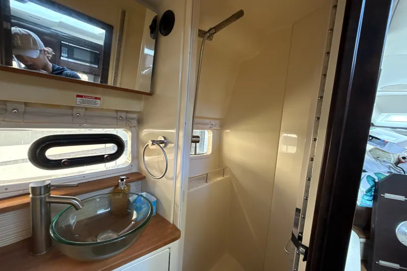 Slide: The Image of 2018 Sea Ray Sundancer 350 Coupe bathroom with glass sink and shower. - 64