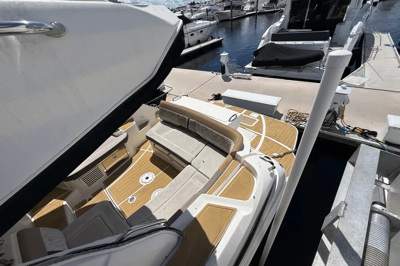 Slide: The Image of 2018 Sea Ray Sundancer 350 Coupe docked, showcasing spacious seating and elegant deck design. - 121