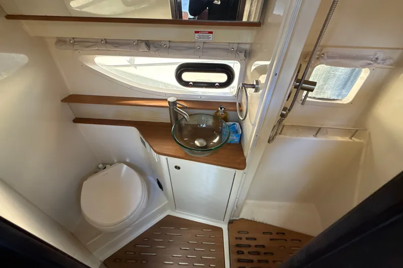 Slide: The Image of 2018 Sea Ray Sundancer 350 Coupe bathroom with modern fixtures and wooden accents. - 63