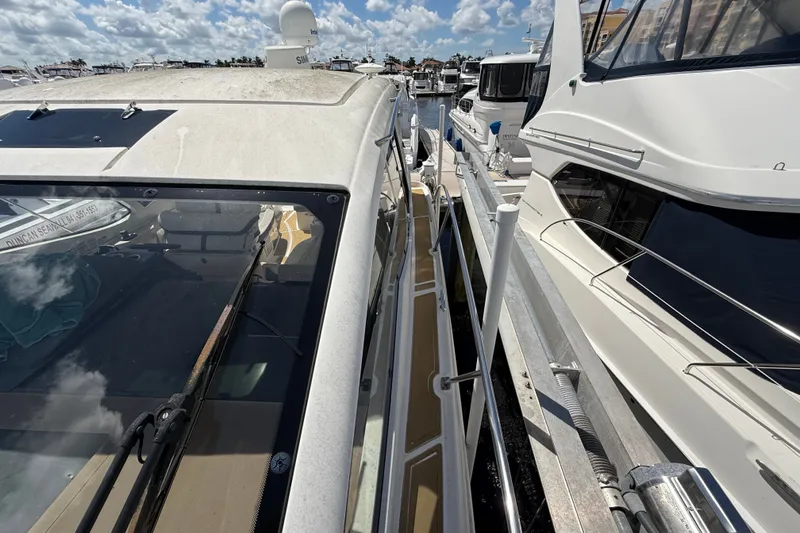 Slide: The Image of 2018 Sea Ray Sundancer 350 Coupe docked at marina under blue sky. - 117