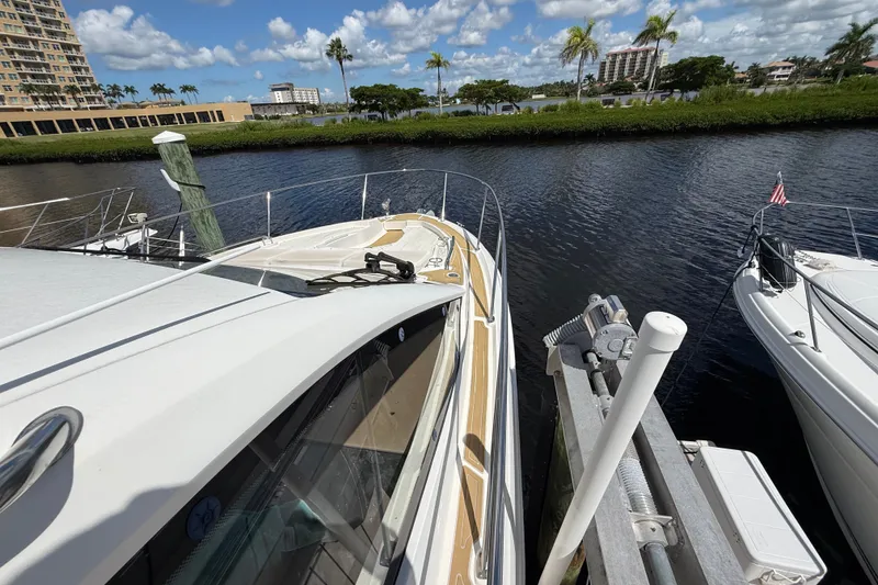 Slide: The Image of 2018 Sea Ray Sundancer 350 Coupe docked by a scenic waterfront with palm trees. - 103