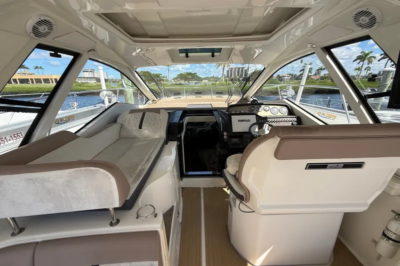 Slide: The Image of Interior view of 2018 Sea Ray Sundancer 350 Coupe cockpit with seating and navigation controls. - 21