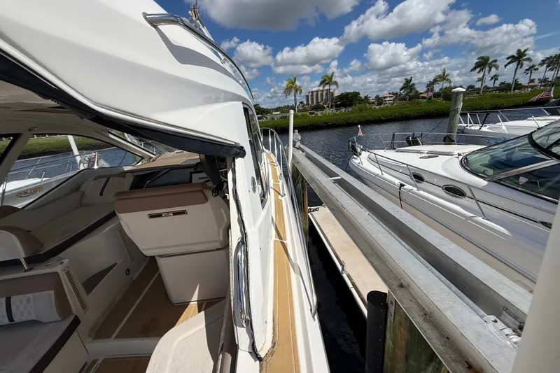 Slide: The Image of 2018 Sea Ray Sundancer 350 Coupe docked, showcasing sleek design and luxurious interior. - 100