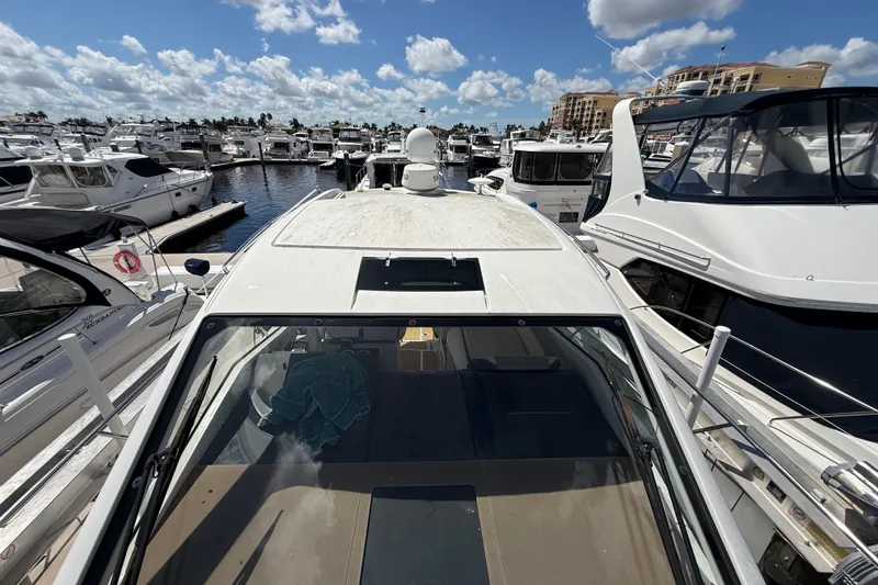 Slide: The Image of 2018 Sea Ray Sundancer 350 Coupe docked at a marina under a blue sky. - 113