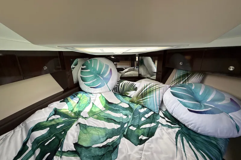 Slide: The Image of 2018 Sea Ray Sundancer 350 Coupe cabin with tropical-themed bedding and pillows. - 53