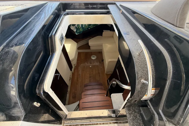 Slide: The Image of View into the cabin of a 2018 Sea Ray Sundancer 350 Coupe with wooden steps and seating area. - 31