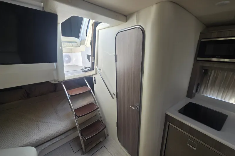 Slide: The Image of Interior of 2022 Regal 33 Express boat with stairs, bed, and kitchenette. - 24