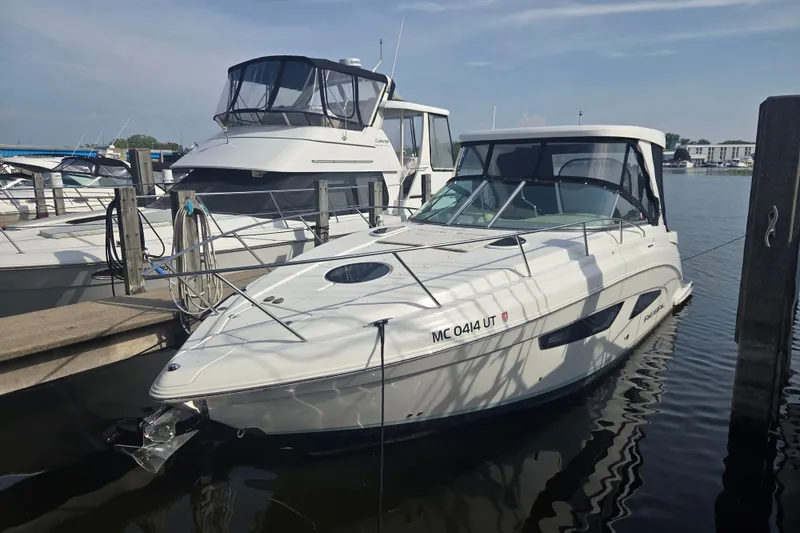 The Image of 2022 Regal 33 Express boat docked at marina under clear sky. - 0