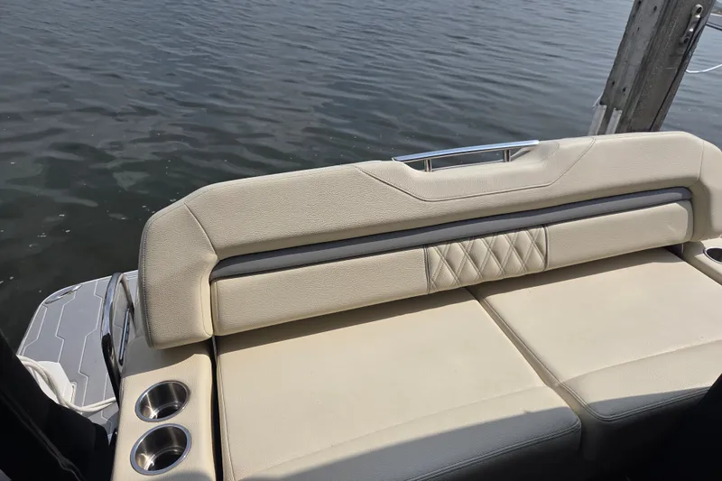 Slide: The Image of Luxury seating on 2022 Regal 33 Express boat, featuring cup holders and water view. - 16
