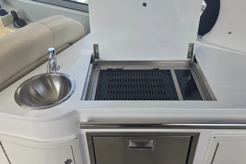 Slide: The Image of 2022 Regal 33 Express yacht kitchenette with sink and grill. - 19