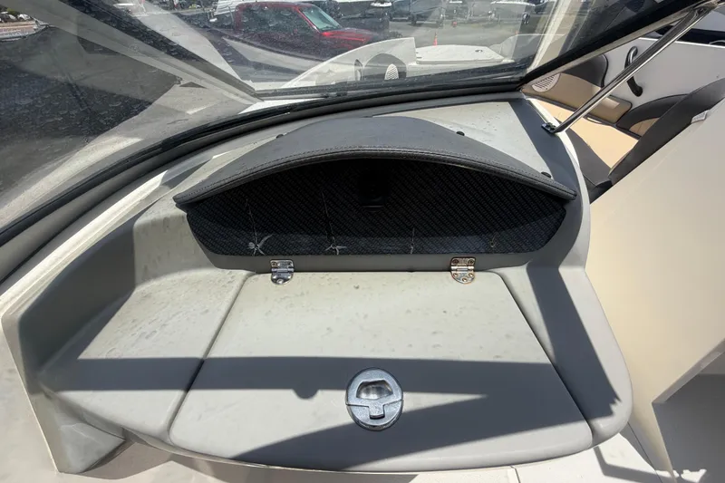 Slide: The Image of 2018 Stingray 204 LR boat dashboard with storage compartment and windshield view. - 22