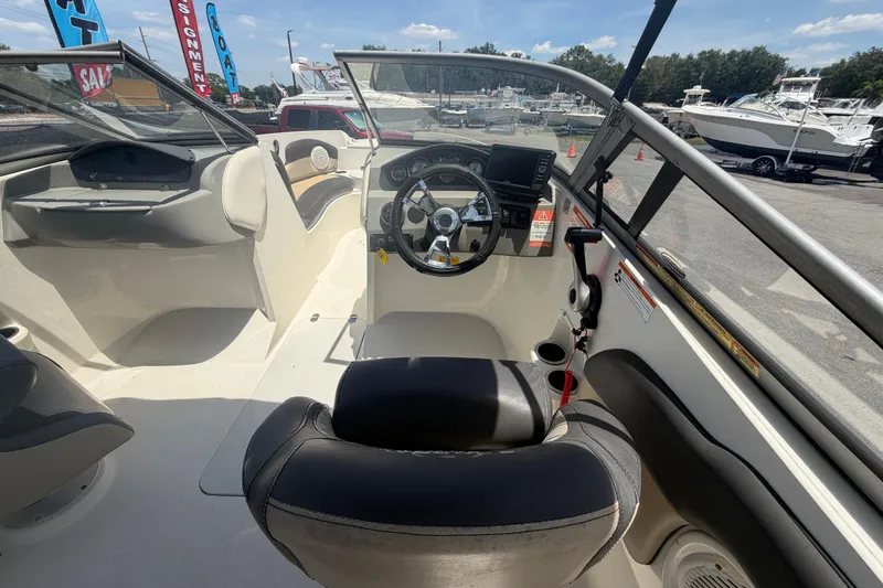 Slide: The Image of Interior view of a 2018 Stingray 204 LR boat, showcasing the steering console and seating. - 15