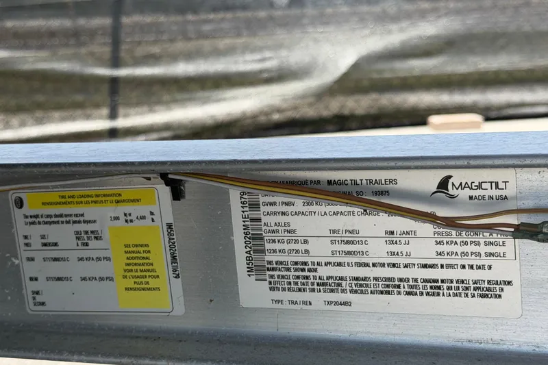 Slide: The Image of Label details on a Magic Tilt trailer, showcasing tire and loading information. - 61