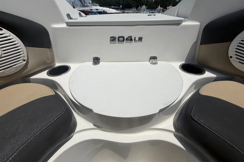 Slide: The Image of 2018 Stingray 204 LR boat interior with seating and cup holders. - 32