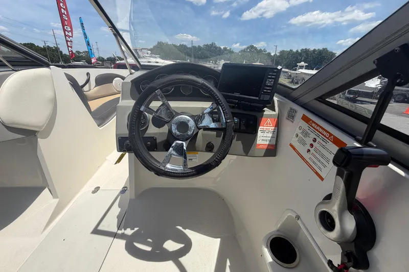 Slide: The Image of 2018 Stingray 204 LR boat cockpit with steering wheel and control panel. - 16