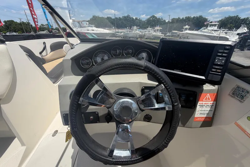 Slide: The Image of 2018 Stingray 204 LR boat dashboard with steering wheel and Garmin navigation system. - 17