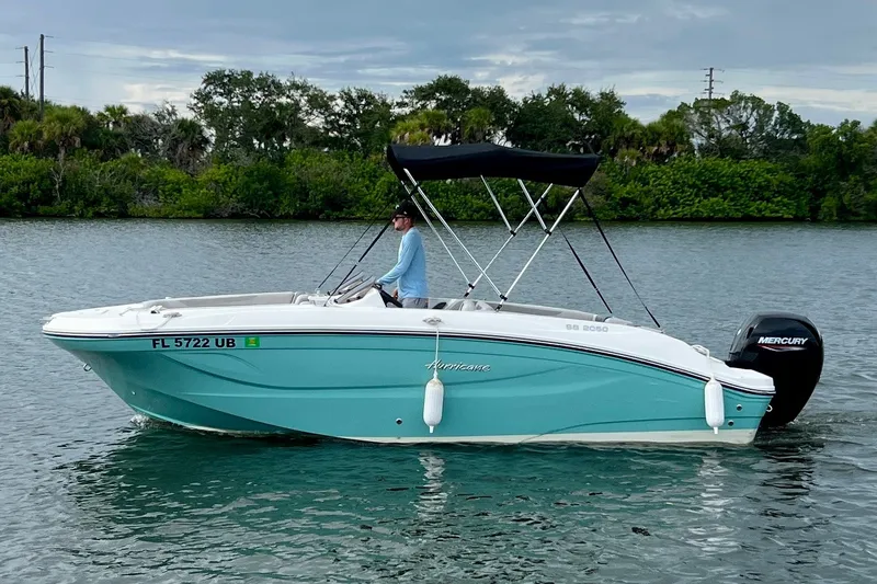 Slide: The Image of 2026 Hurricane SunDeck Sport 2050 OB boat on water, featuring a sleek design and Mercury outboard. - 1