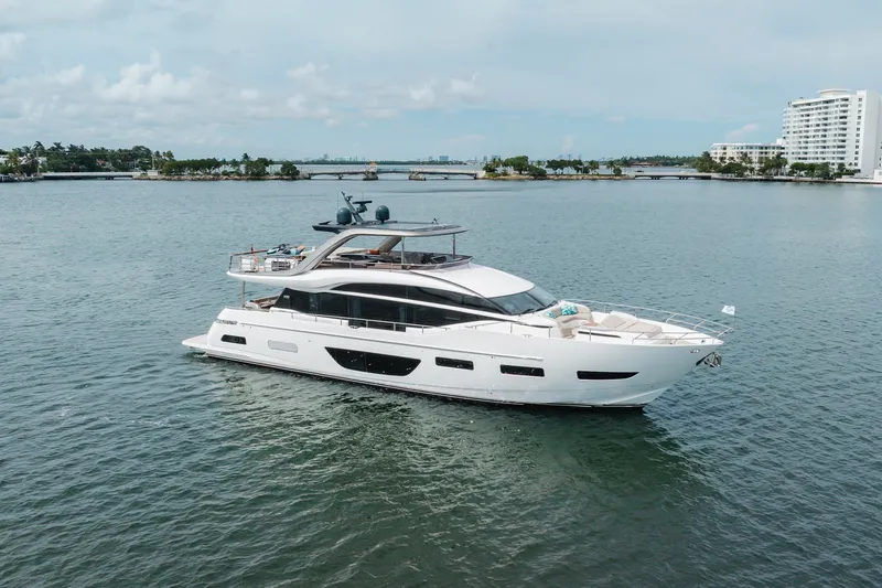 Slide: The Image of Luxurious 2021 Princess Y85 yacht cruising on serene waters near coastal buildings. - 11