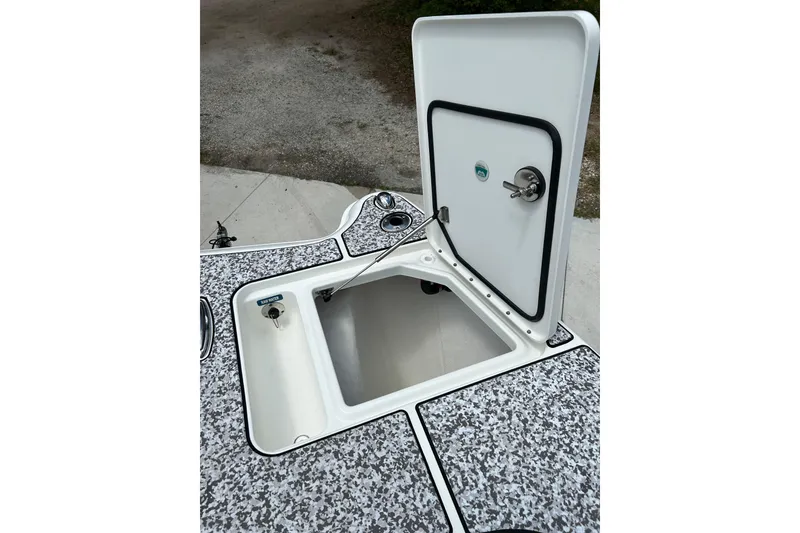 Slide: The Image of Open storage compartment on 2018 World Cat 320 CC boat, featuring a secure latch system. - 25