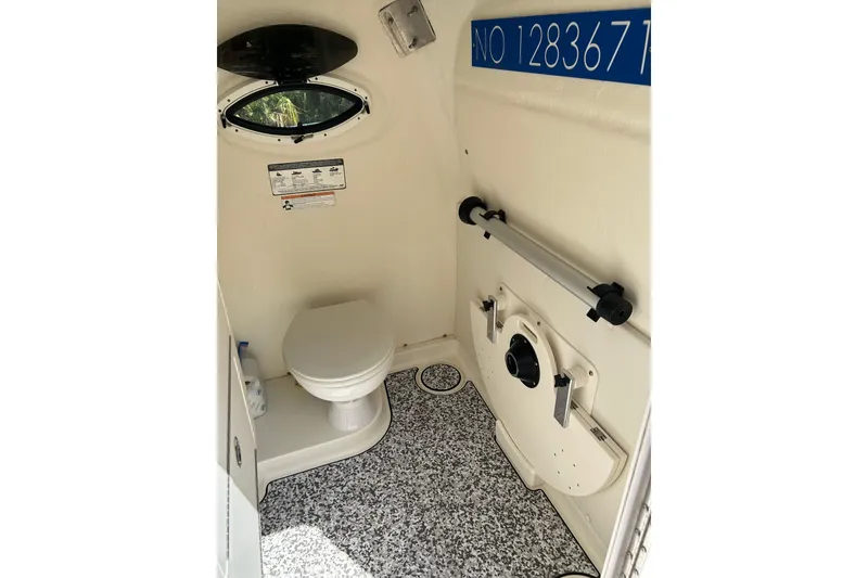 Slide: The Image of Interior of 2018 World Cat 320 CC boat bathroom with toilet and porthole. - 13