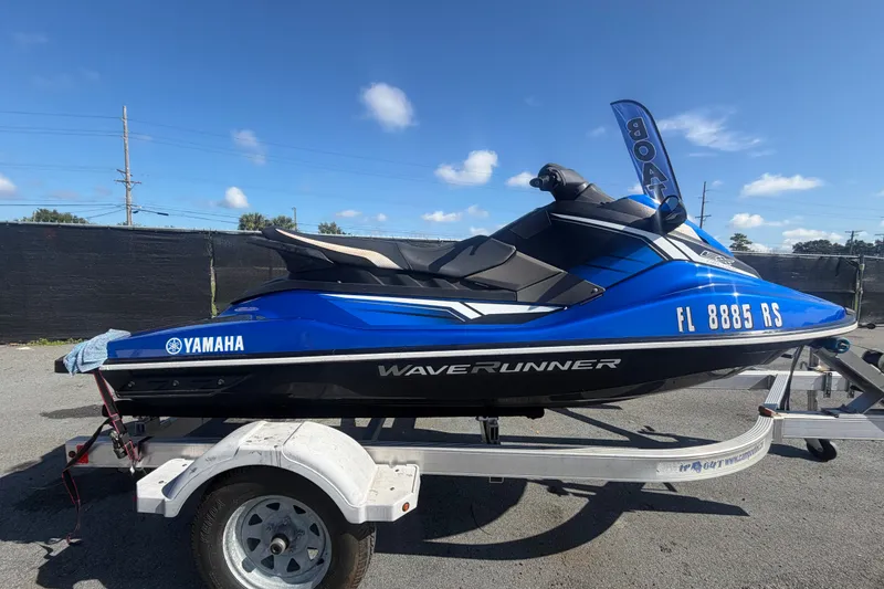 Slide: The Image of 2018 Yamaha WaveRunner EX Deluxe on trailer, blue and black design, parked outdoors. - 1